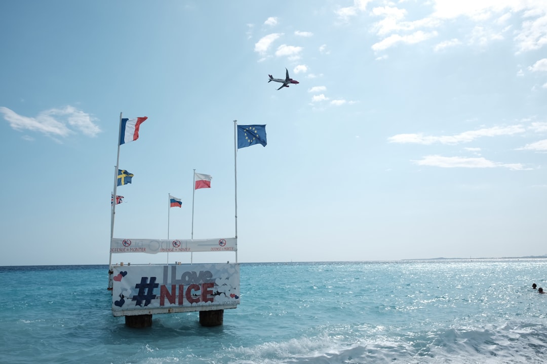 a plane flying over a sign in the ocean