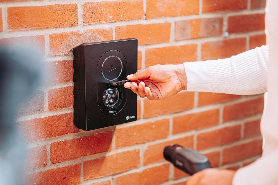 A woman is pressing a button on a brick wall