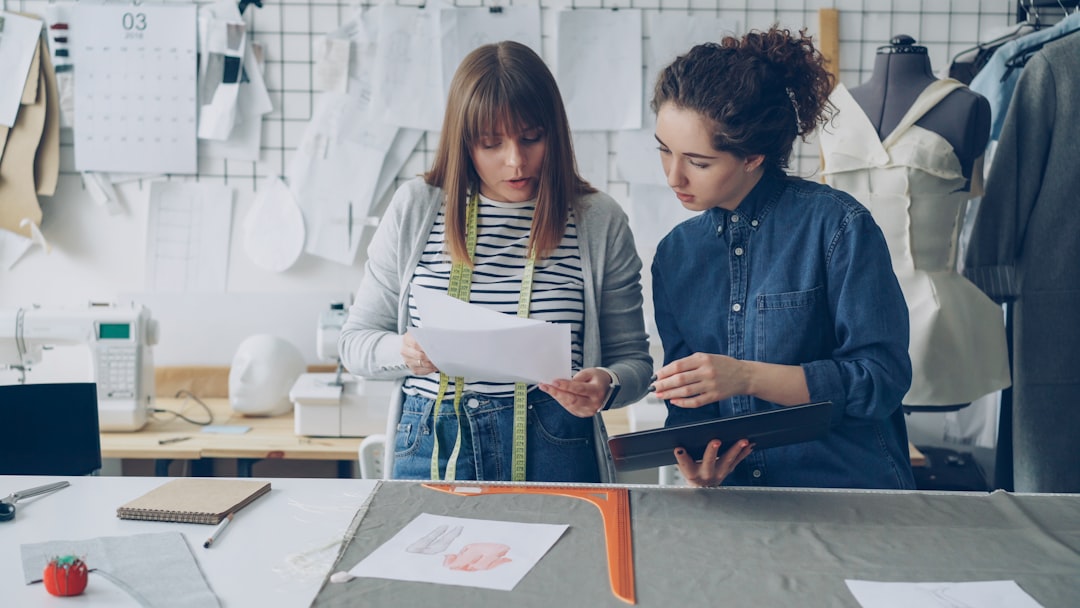 Fashion designers collaborating on designs in a studio.