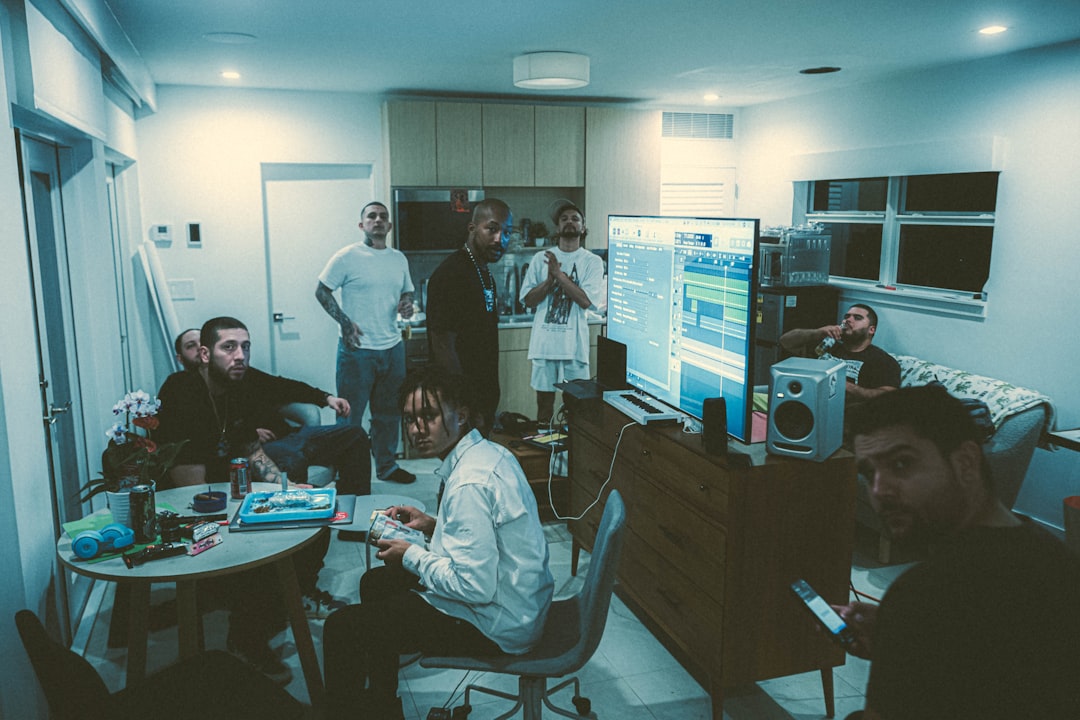 a group of people standing and sitting around a living room