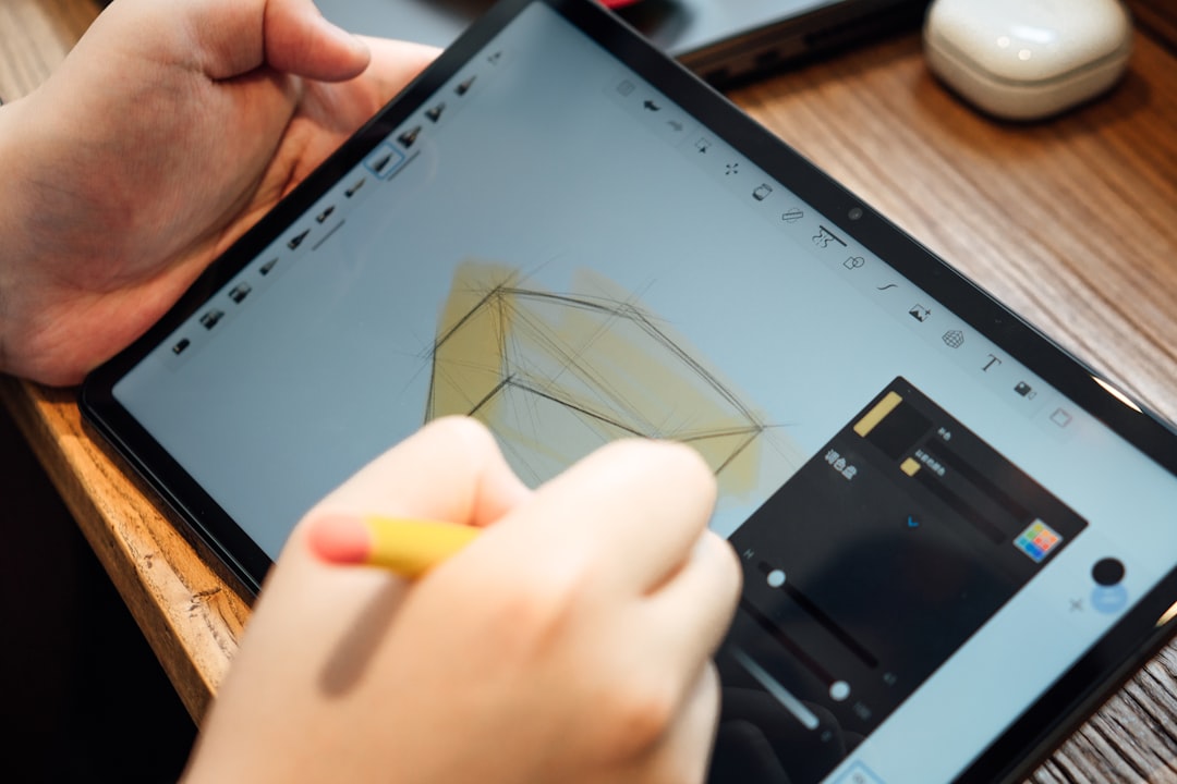 a person holding a pencil and a tablet