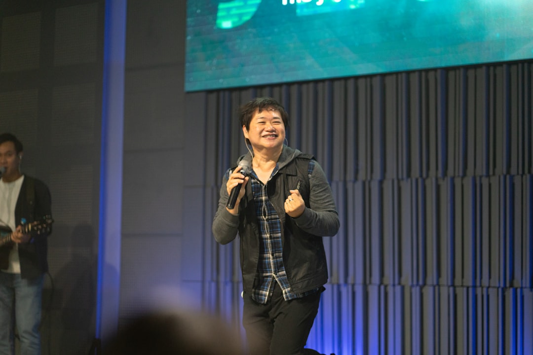 A man speaking into a microphone on stage.
