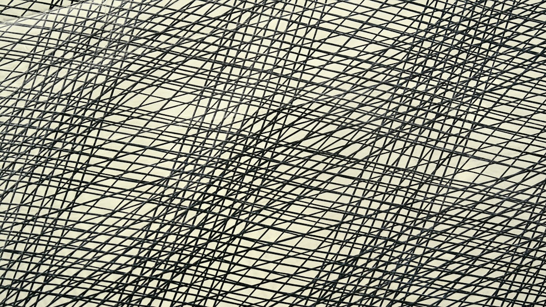 Abstract pattern of intersecting black lines on cream background