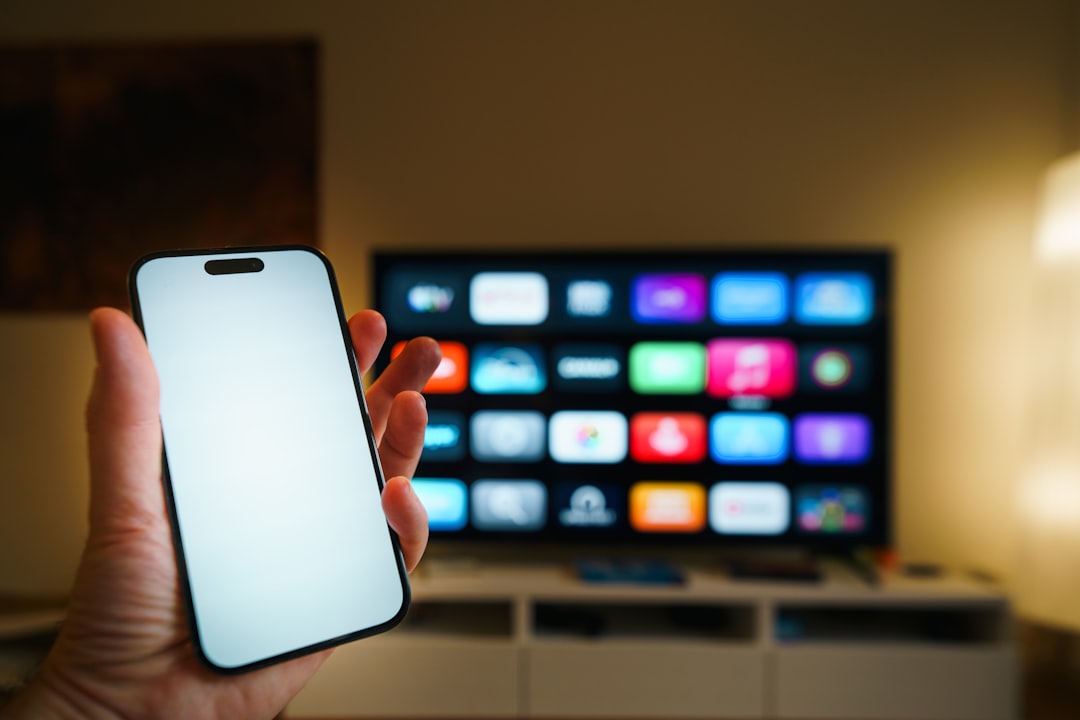 Smartphone held in front of a smart TV screen